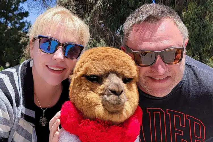 Fertur clients pose with an alpaca in Cusco